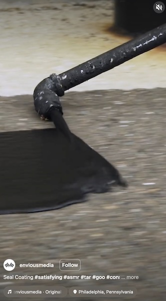 Close-up sealcoating detail shot — squeegee applying sealer